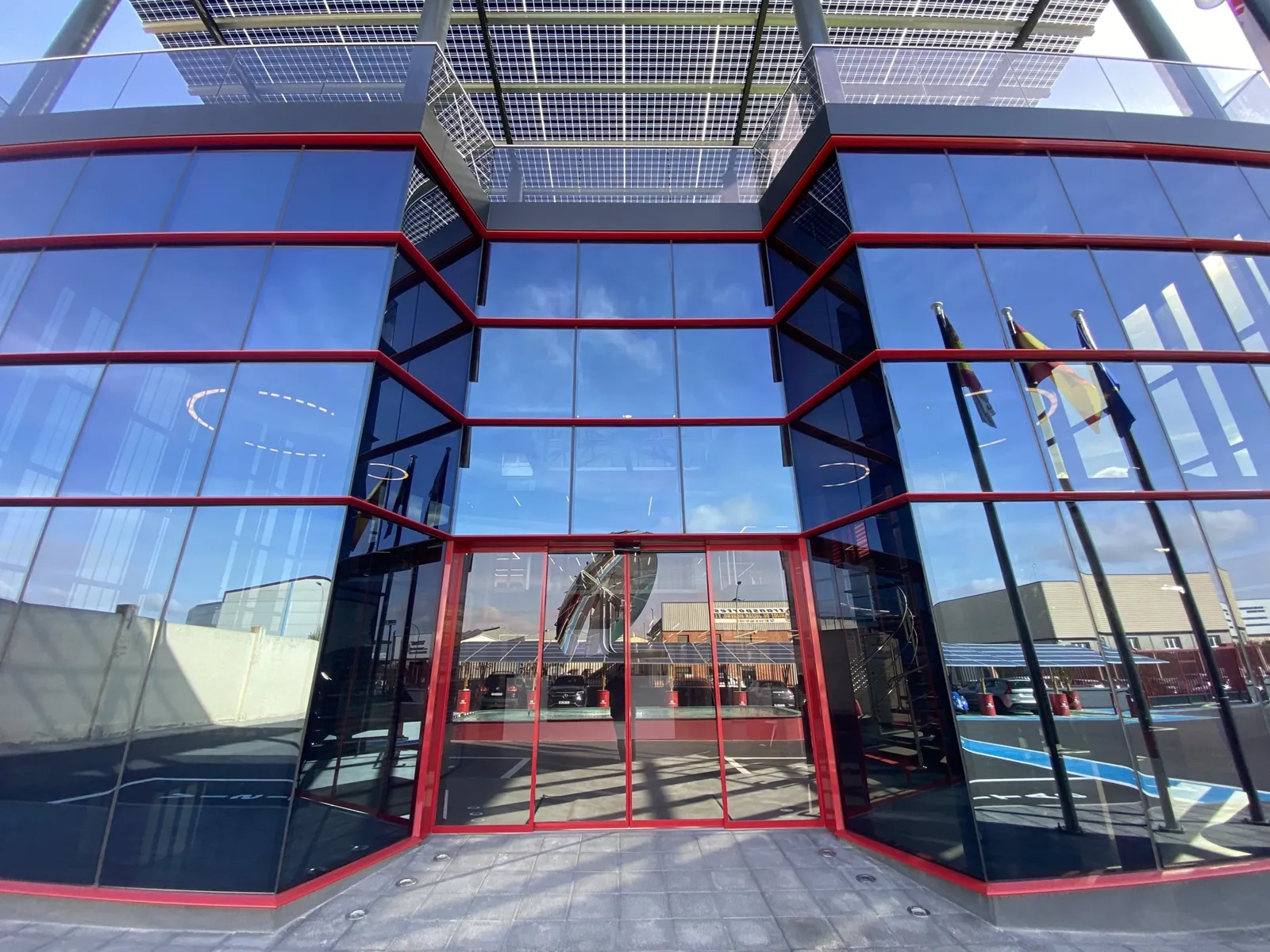 Fachada acristalada del edificio de ER Ingeniería en Villarrobledo, con la marquesina de placas solares