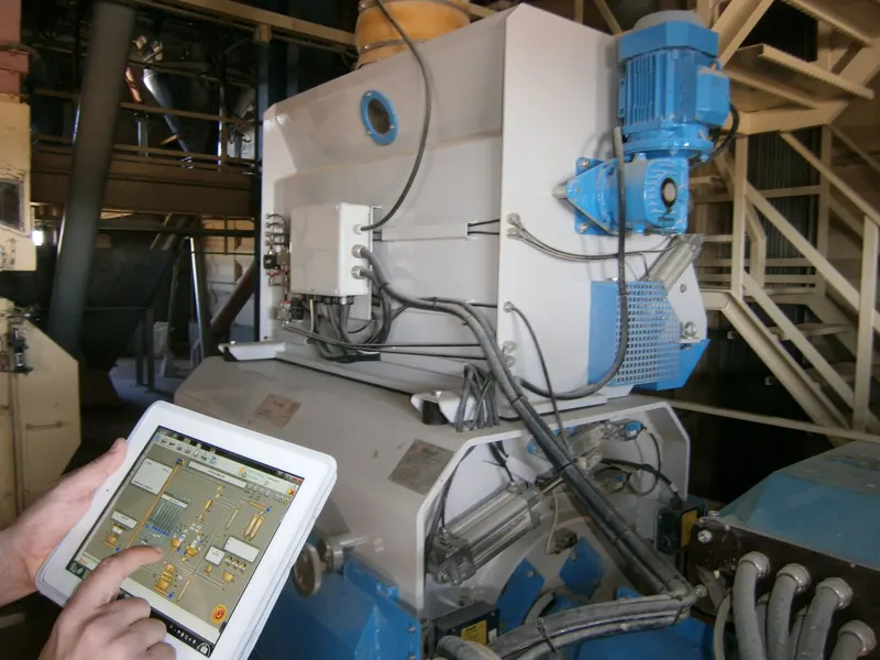 Operario consultando SuitER en una tablet junto a la maquinaria